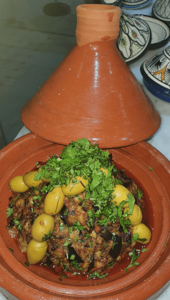 A bowl of Moroccan zaalouk, a smoky eggplant and tomato dip, garnished with fresh parsley and served with crusty bread